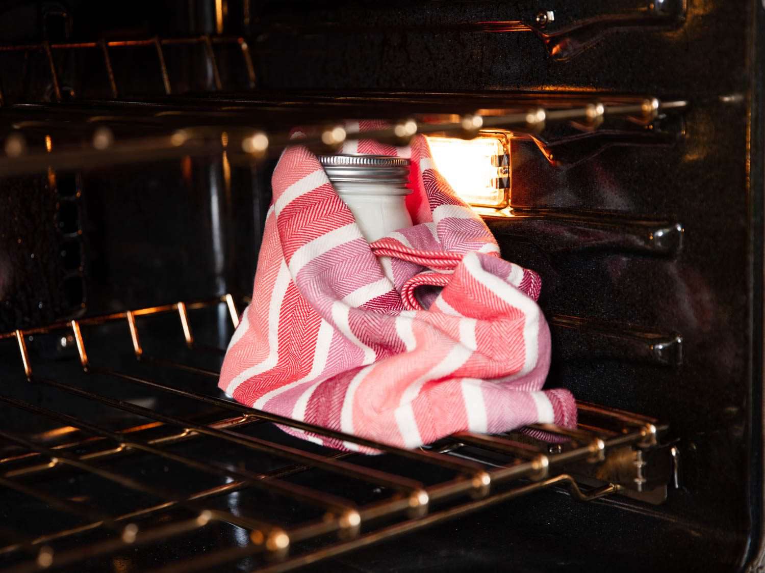 用毛巾把酸奶包好，然后把它放在关闭的烤箱里，开着灯，这样可以让它保持足够的温度。＂class=