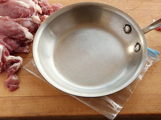 用粗煎锅将生西冷肉片捣平。切片装在塑料袋里，两边切好。