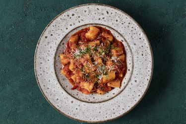 Ricotta gnocchi in tomato sauce on a ceramic plate.