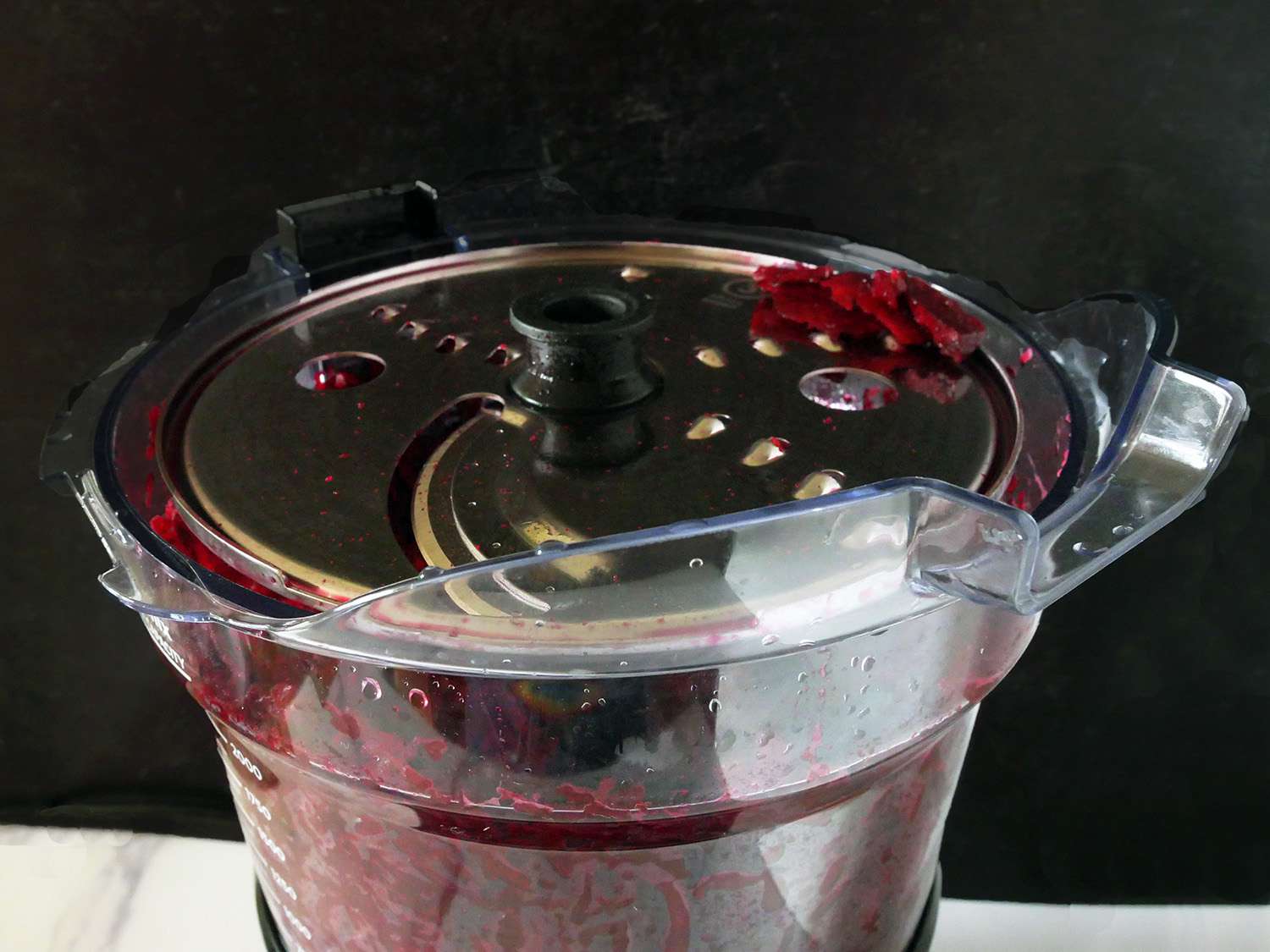 一个特写镜头的食品加工机与碎盘后切碎甜菜。