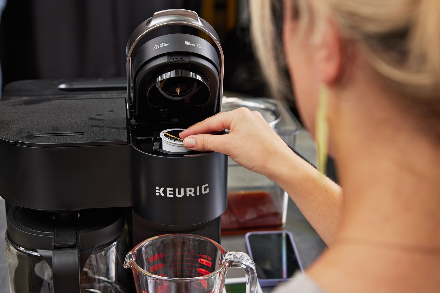 一个人把一个k杯咖啡豆荚放进Keurig咖啡机