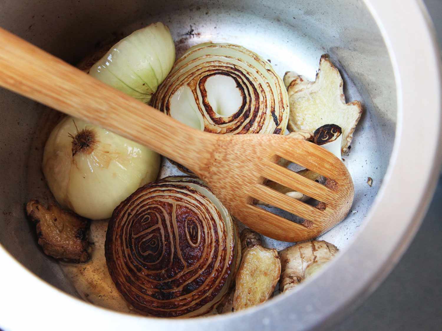 在高压锅里烤洋葱和香料做越南河粉。