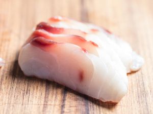 片sushi-grade生鱼在木板上。