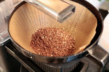 一个特写镜头的咖啡渣放置在过滤器在一个煮篮子