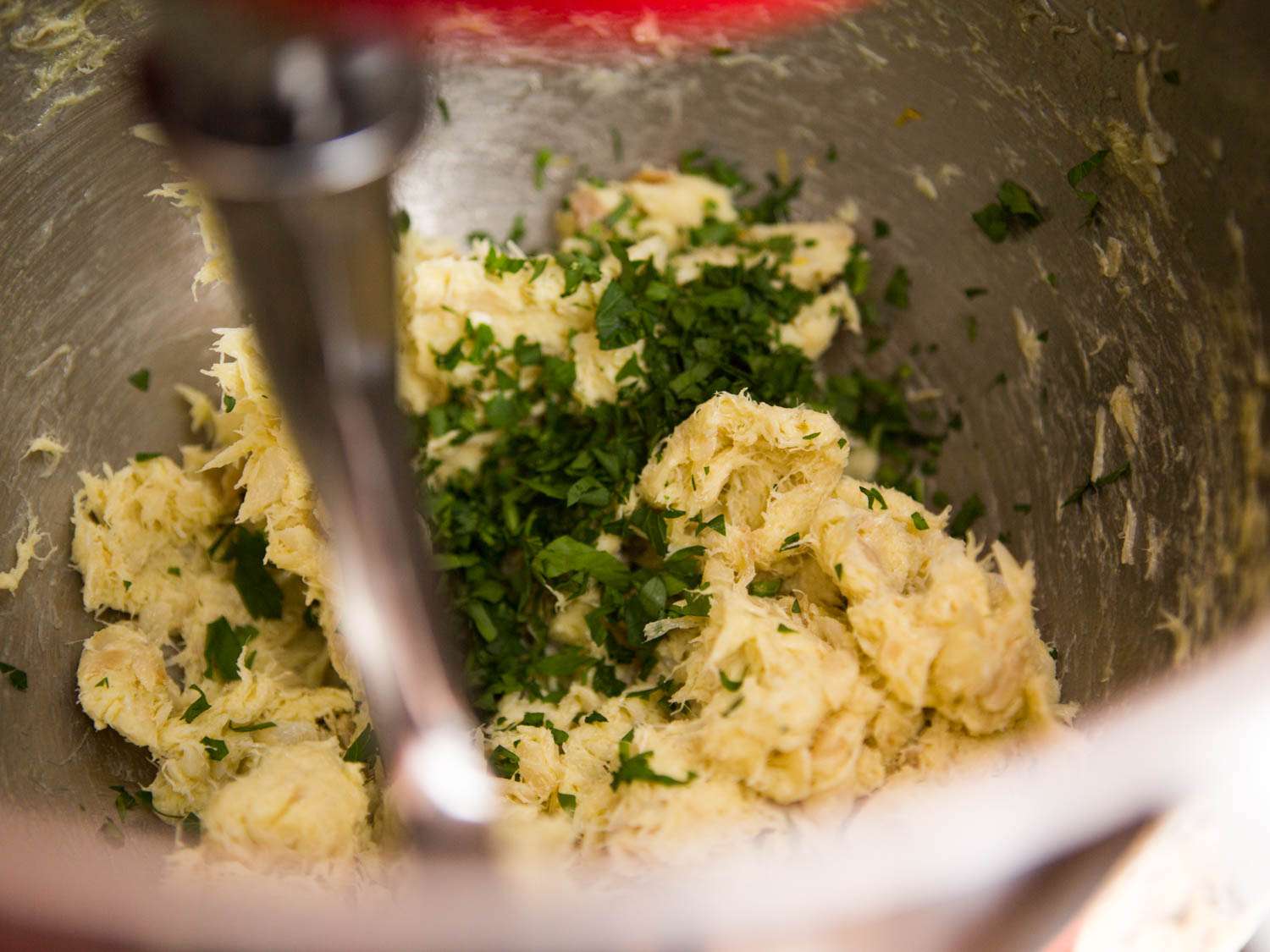 The brandade in the bowl of a stand mixer with lemon zest and parsley added.