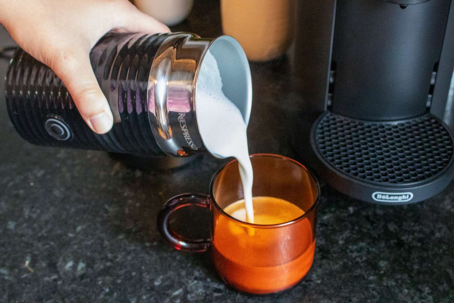 Nespresso牛奶起泡机将起泡的牛奶倒入煮好的咖啡杯中