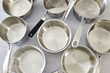 a number of small saucepans on a grey surface