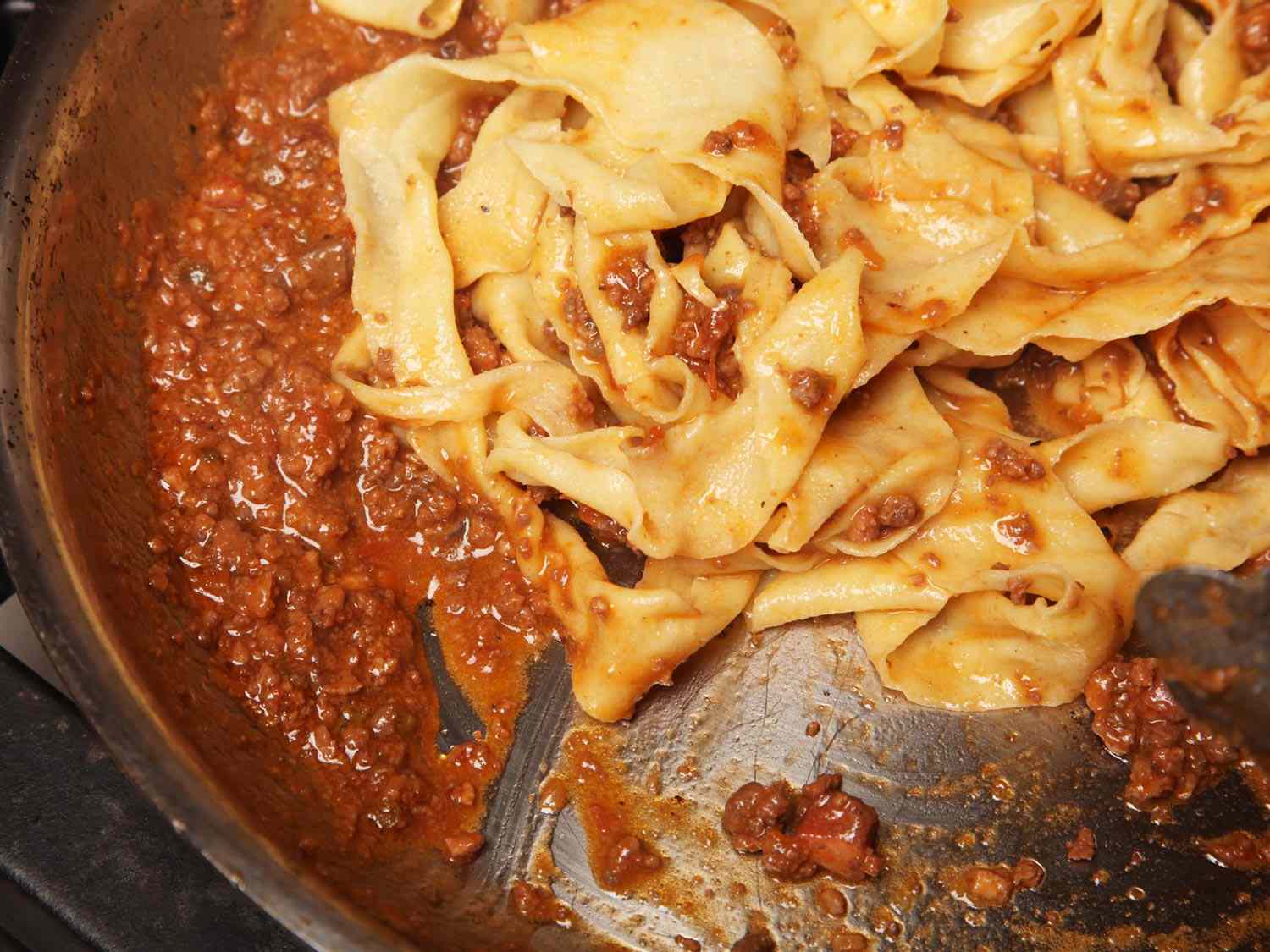 煮熟的意大利扁面条和ragù肉酱一起放在一个宽大的斜面平底锅里(sauteuse)。gydF4y2Ba