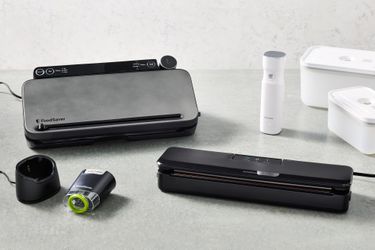 an array of handheld and countertop vacuum sealers on gray countertop