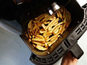 煮熟的薯条在空气炸锅篮子中途手拉篮