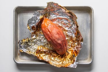 Frozen roasted sweet potato on foil in a rimmed baking sheet
