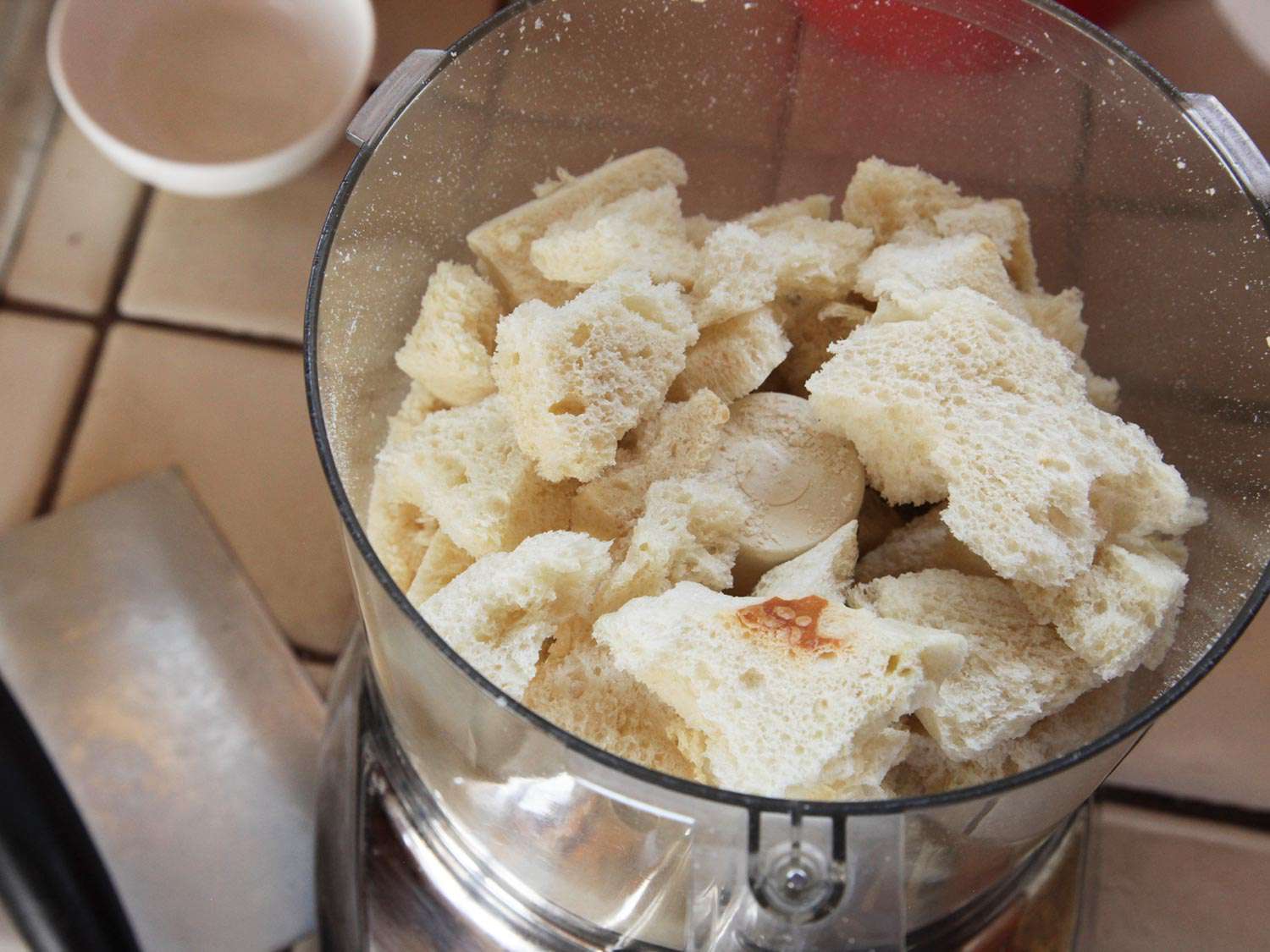 Crustless dehydrated craggy bits of bread in food processor bowl