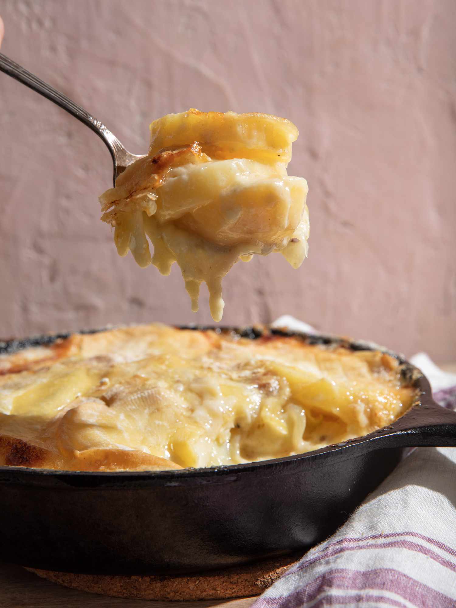 一勺tartiflette从锅里端出来，奶酪从嫩土豆上滴下来。