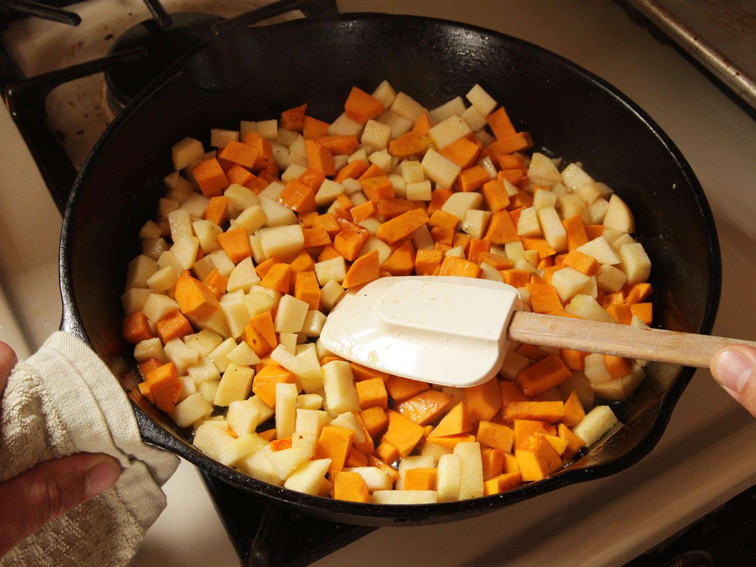 将苹果丁和南瓜丁放入铸铁煎锅中煸炒。