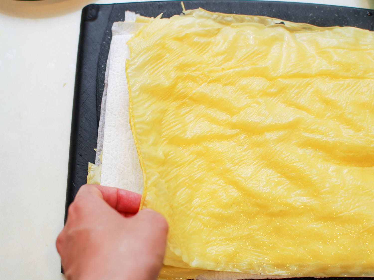 再水化的豆腐片被叠在纸巾层之间。