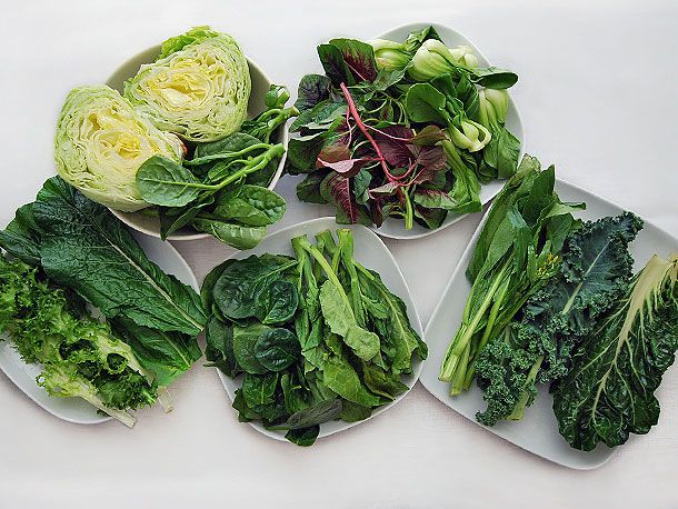 五个白色盘子里盛着各种各样的中国绿色蔬菜。