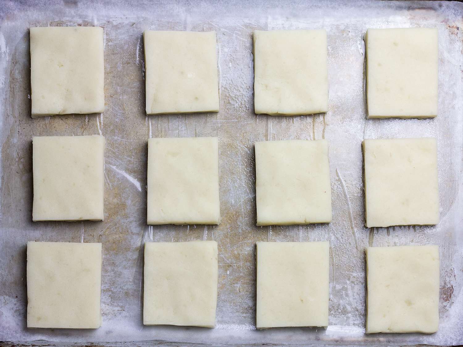 把土豆麻糬面团切成相同的正方形放在烤盘上