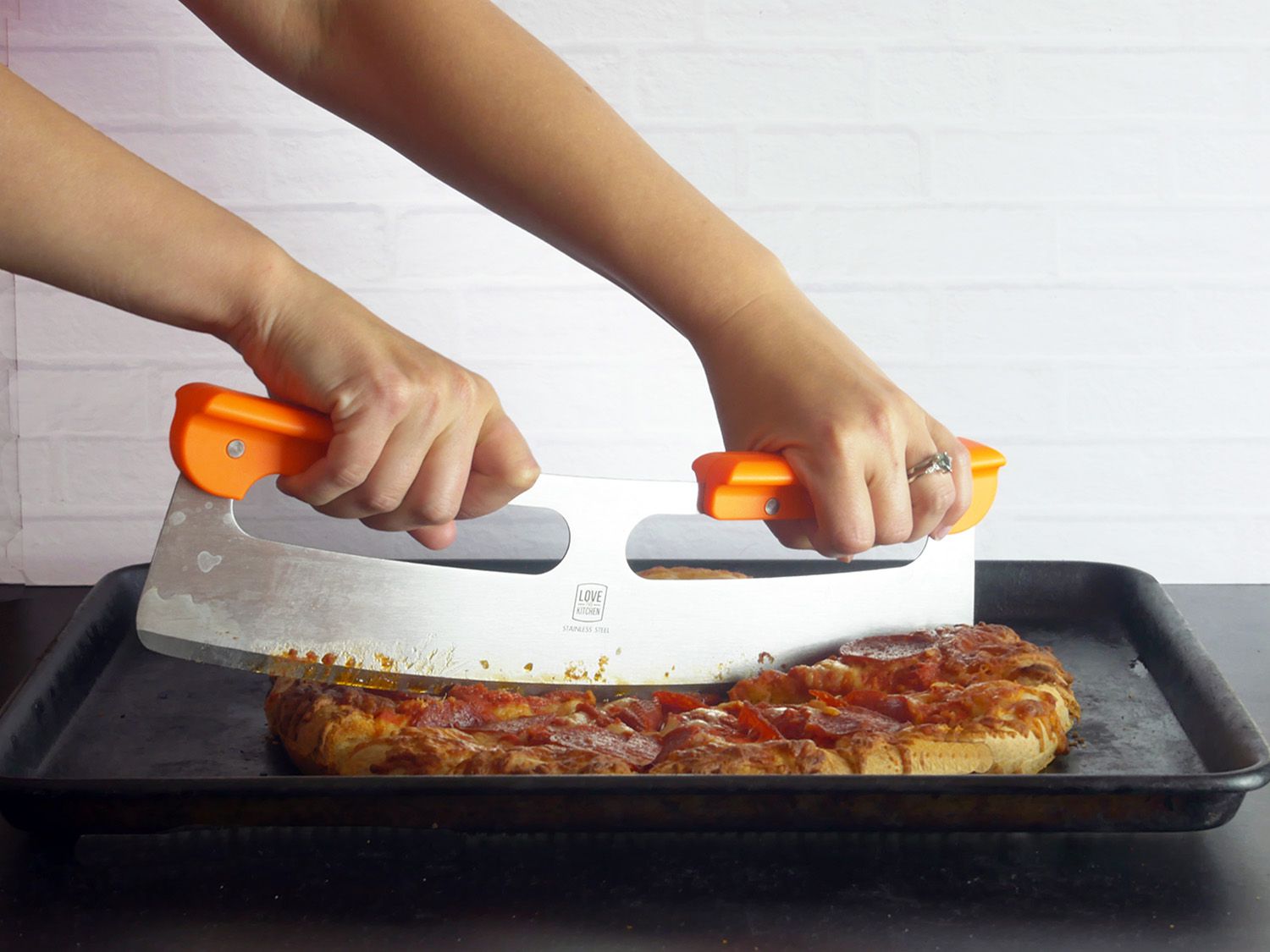 用原来的披萨切割机在托盘上切意大利辣香肠披萨