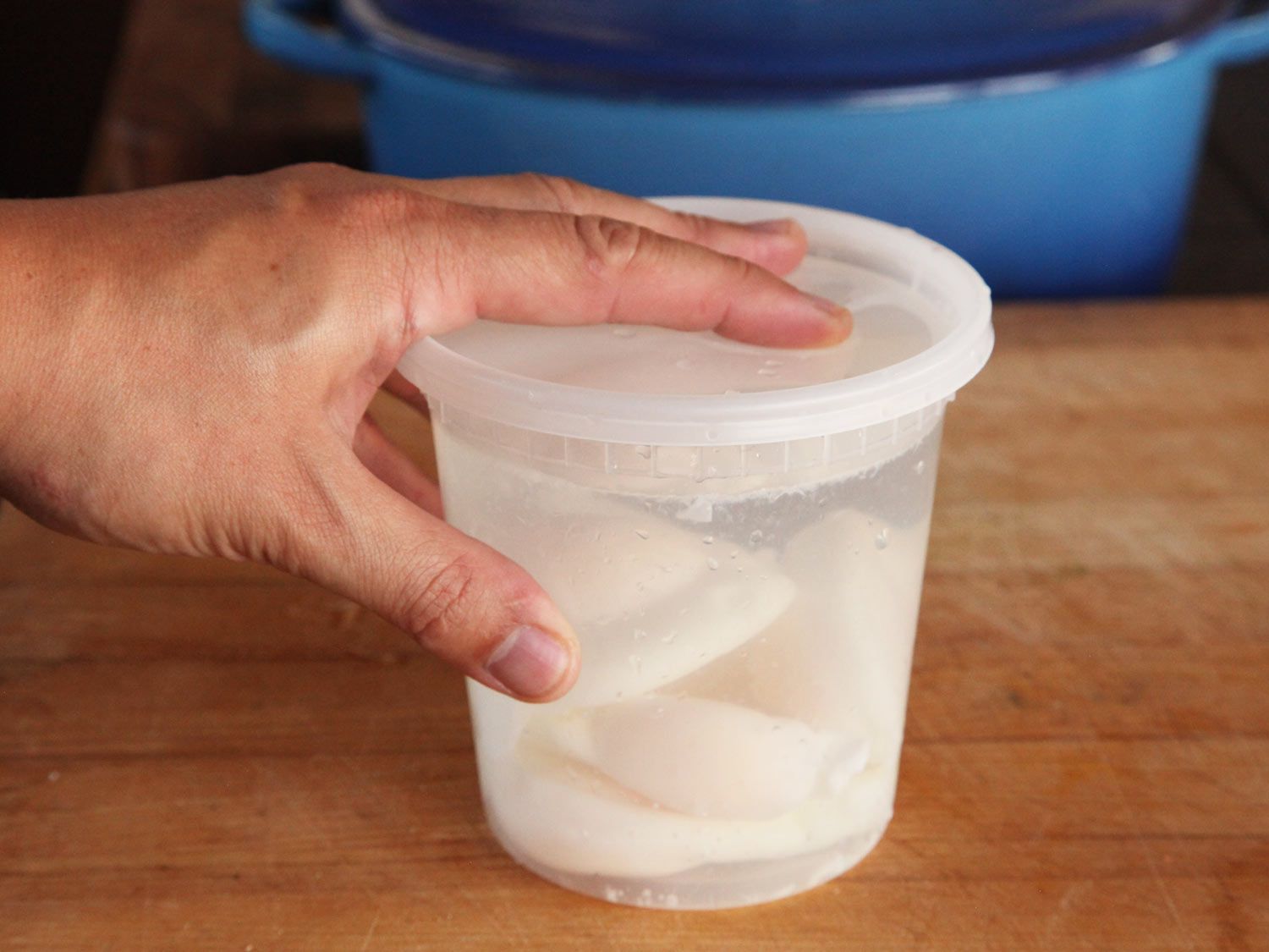 荷包蛋存储在一个塑料熟食容器装满了水