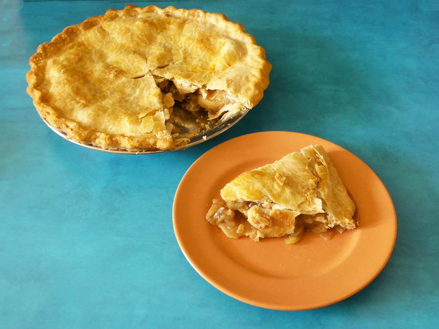 一块派放在盘子里，放在诺普洛锅里的苹果派前面。