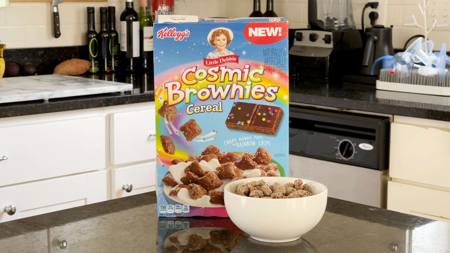 Box of Kellog's Little Debbie Cosmic Brownies Cereal on a counter with a bowl filled with the cereal in the foreground