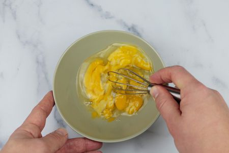 一个小型搅拌打三个鸡蛋在碗里