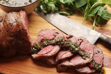 Sous vide lamb leg sliced up topped with chimichurri sauce