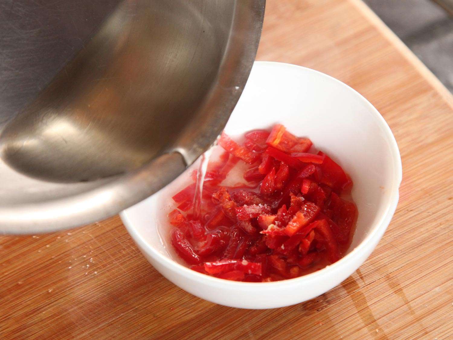 将醋卤倒入一碗泰国辣椒中腌制。