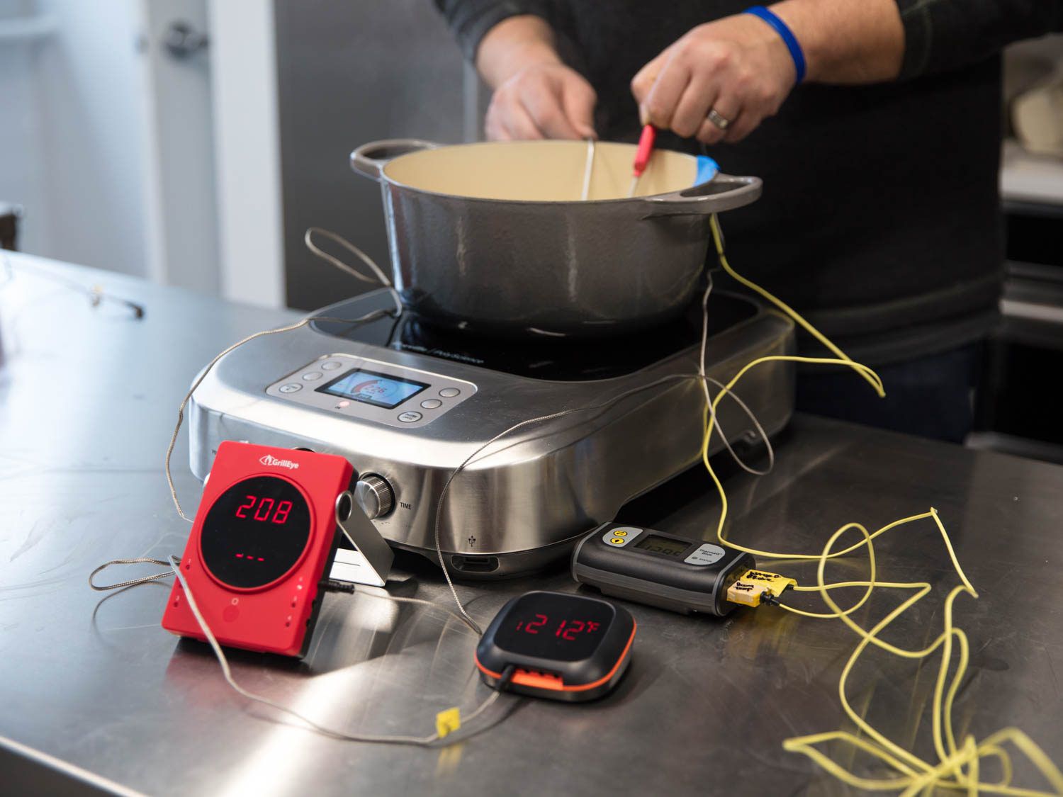 用三个不同的温度计检测感应燃烧器上的荷兰烤箱的沸水温度