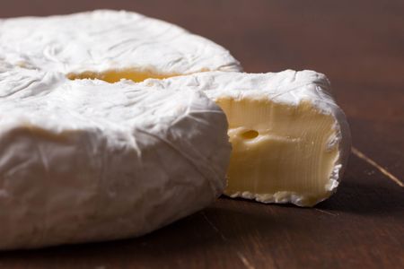 一个轮子的法国奶酪一片切割和稍微疏远她的奶油。