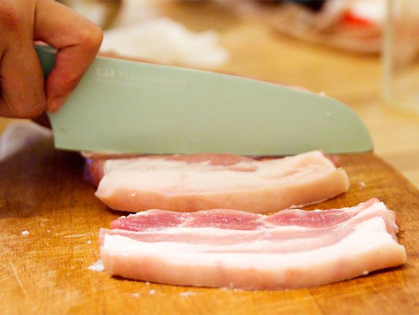 将腌五花肉纵向切成1/2英寸宽的条状。