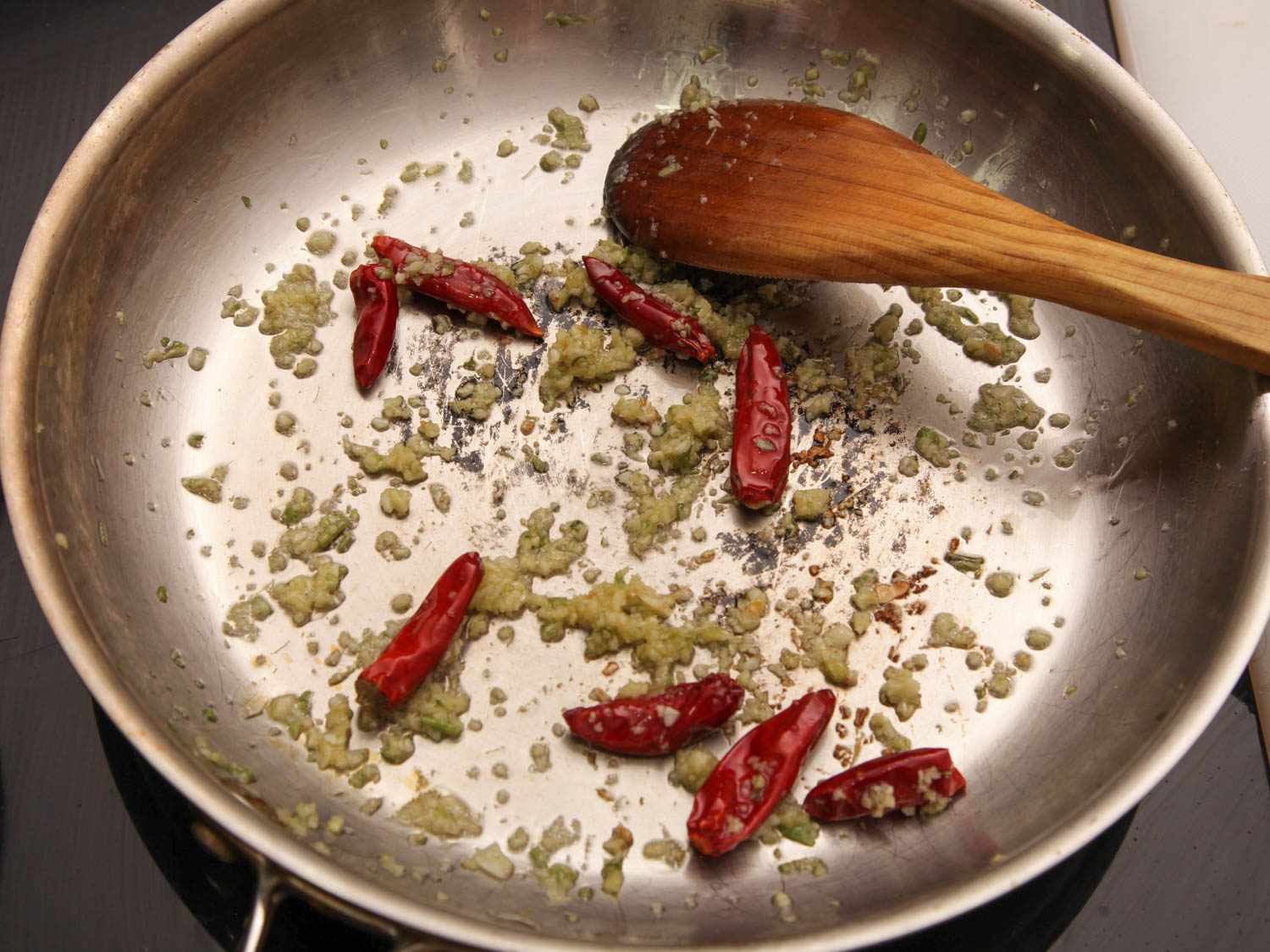 用不锈钢煎锅煎大蒜和辣椒，做左宗棠鸡。gydF4y2Ba