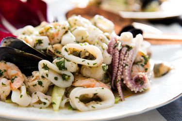 意大利海鲜沙拉，白盘子里有鱿鱼、扇贝、虾和贻贝。