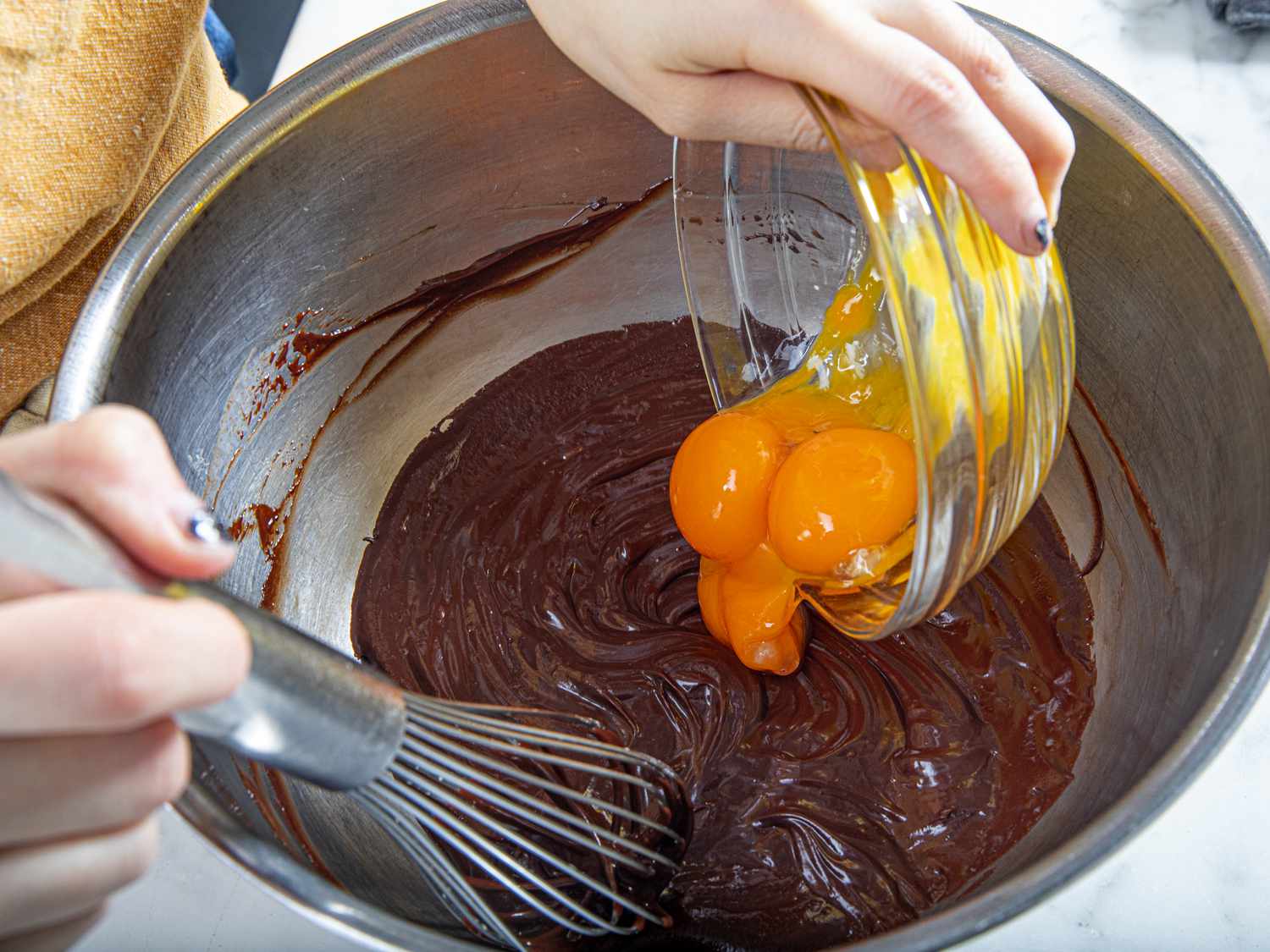 Adding eggs to chocolate mixture
