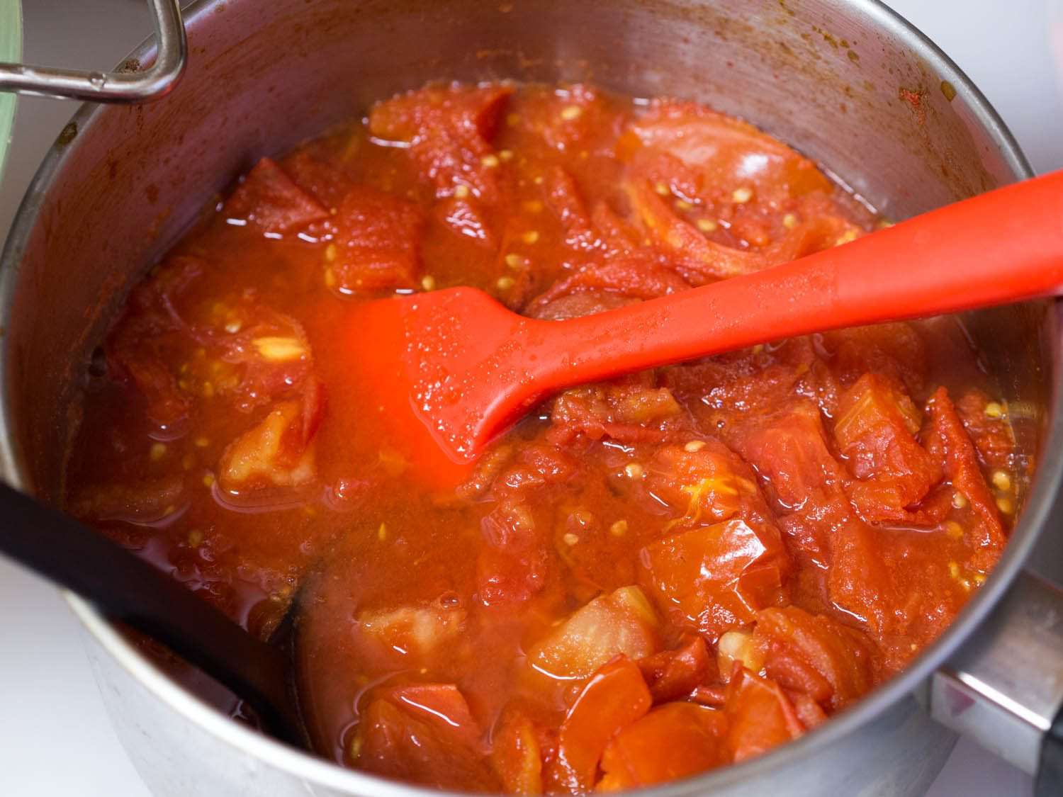 用红色锅铲搅拌一锅番茄酱。