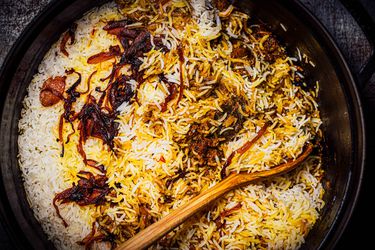 A large bowl of lamb biryani with saffron and caramelized onions by Nik Sharma