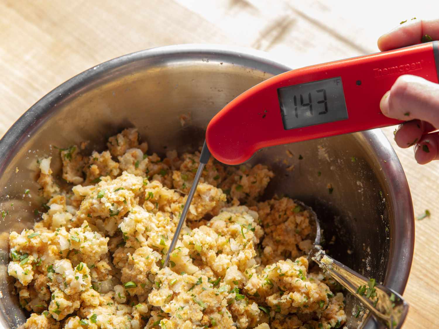 即时读数温度计插入香料土豆混合物混合后，说明它是140Â°F以上