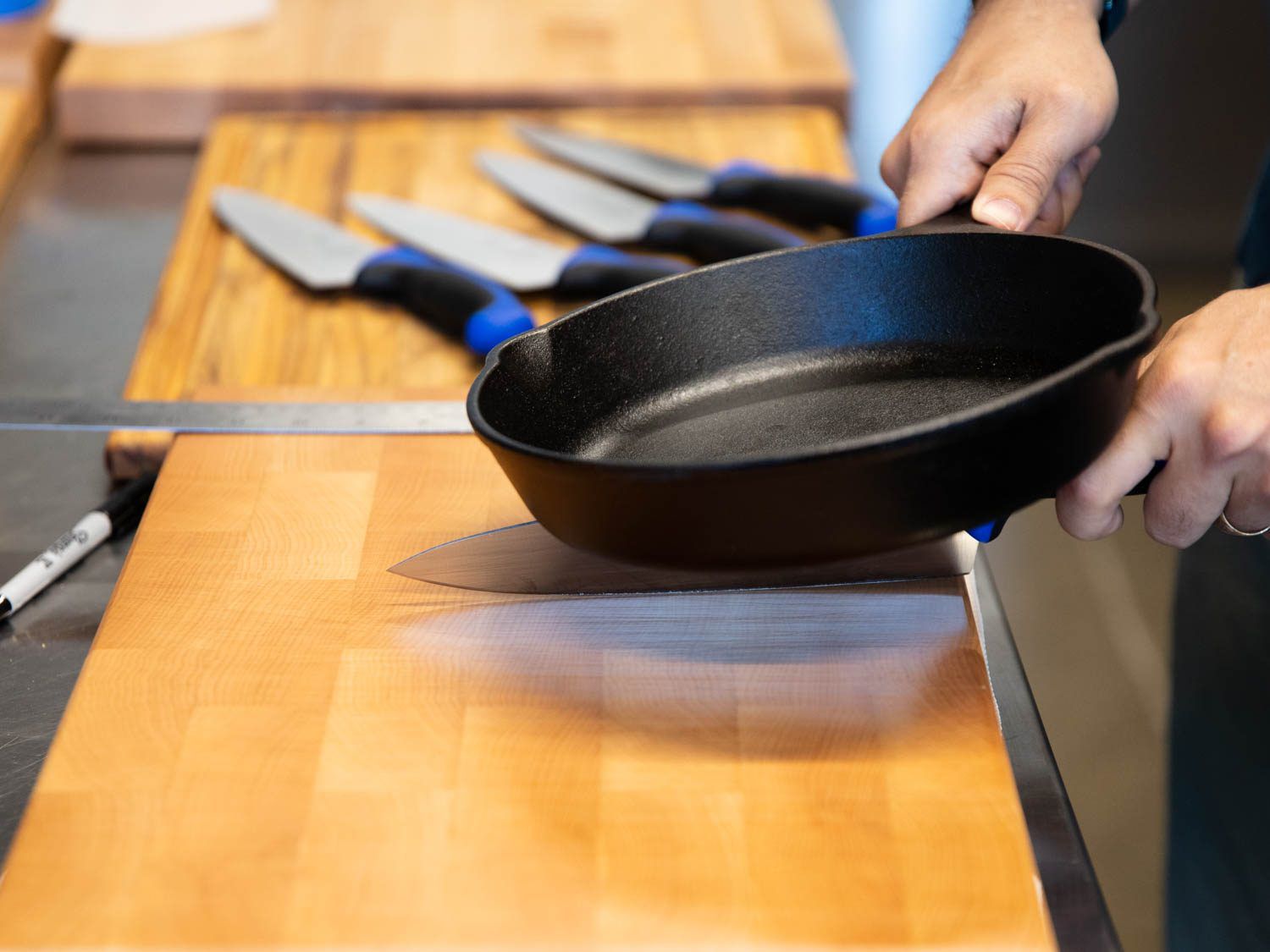测试砧板对刀片的影响:在厨师刀上放置一个4.5磅重的煎锅，沿着设定的行程长度提供一致的压力。
