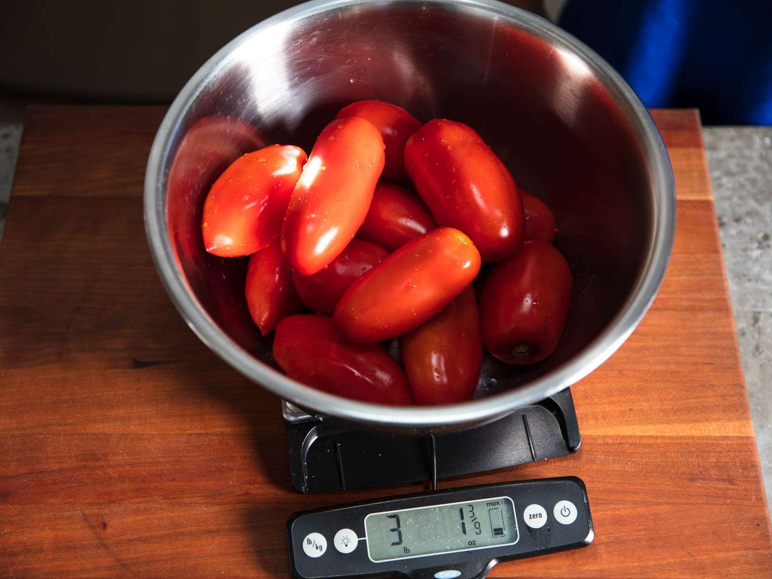 洗过的李子番茄在一个金属碗里用数字秤称重