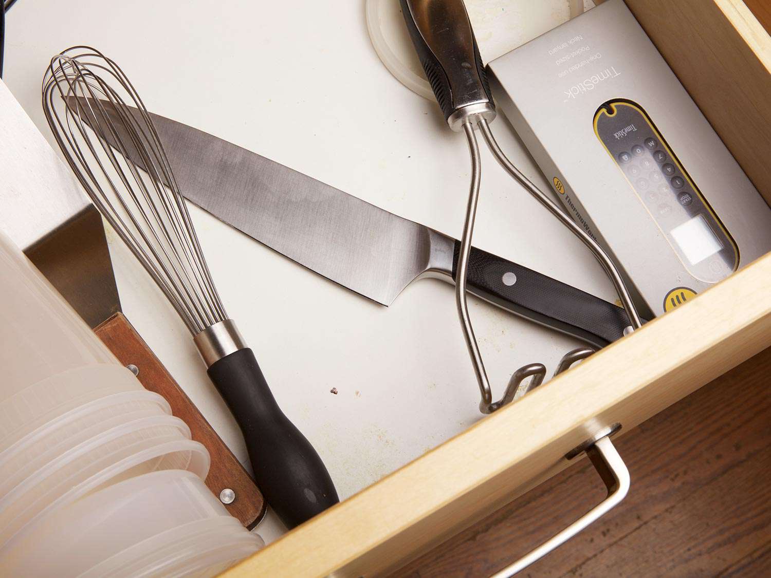 厨房抽屉里的一把刀和其他物品(打蛋器、捣碎土豆机)撞在一起