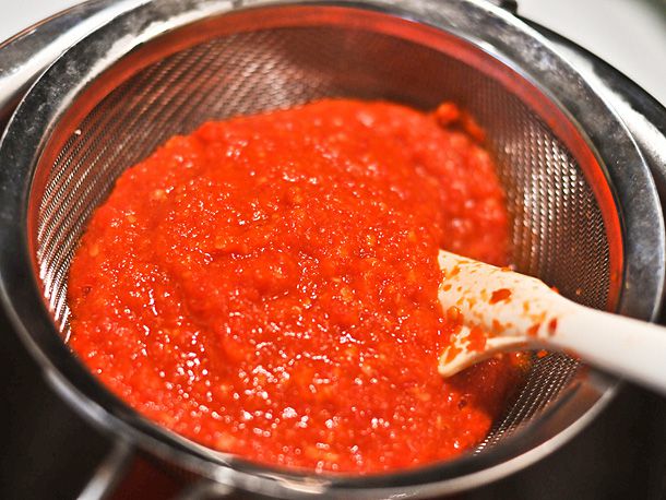 用筛网过滤自制的辣酱。