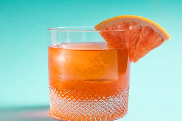 一款不寻常的内格罗尼，阿珀罗，利莱特，杜松子鸡尾酒，杯沿上有一个葡萄柚楔形。