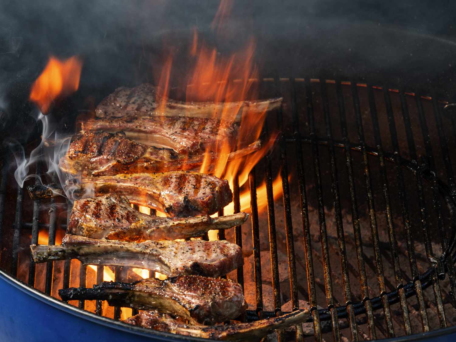 羊排在烤架的左侧，正上方是热炭，由于脂肪的燃烧，羊排周围有火焰。gydF4y2Ba