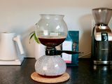 a siphon brewer with its top portion filled with coffee