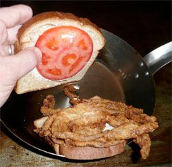 软壳蟹三明治配一片番茄和蛋黄酱。