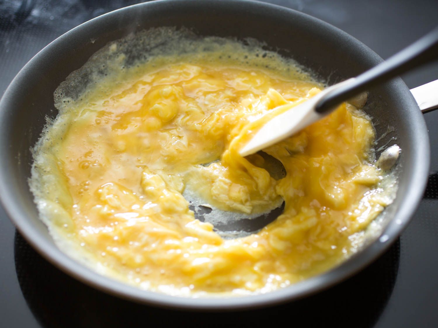 用硅铲在不粘锅里搅拌炒鸡蛋。