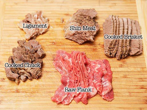 An assortment of meat toppings for pho: ligament, shin meat, cooked brisket, cooked chuck, and raw flank steak cut into slices.