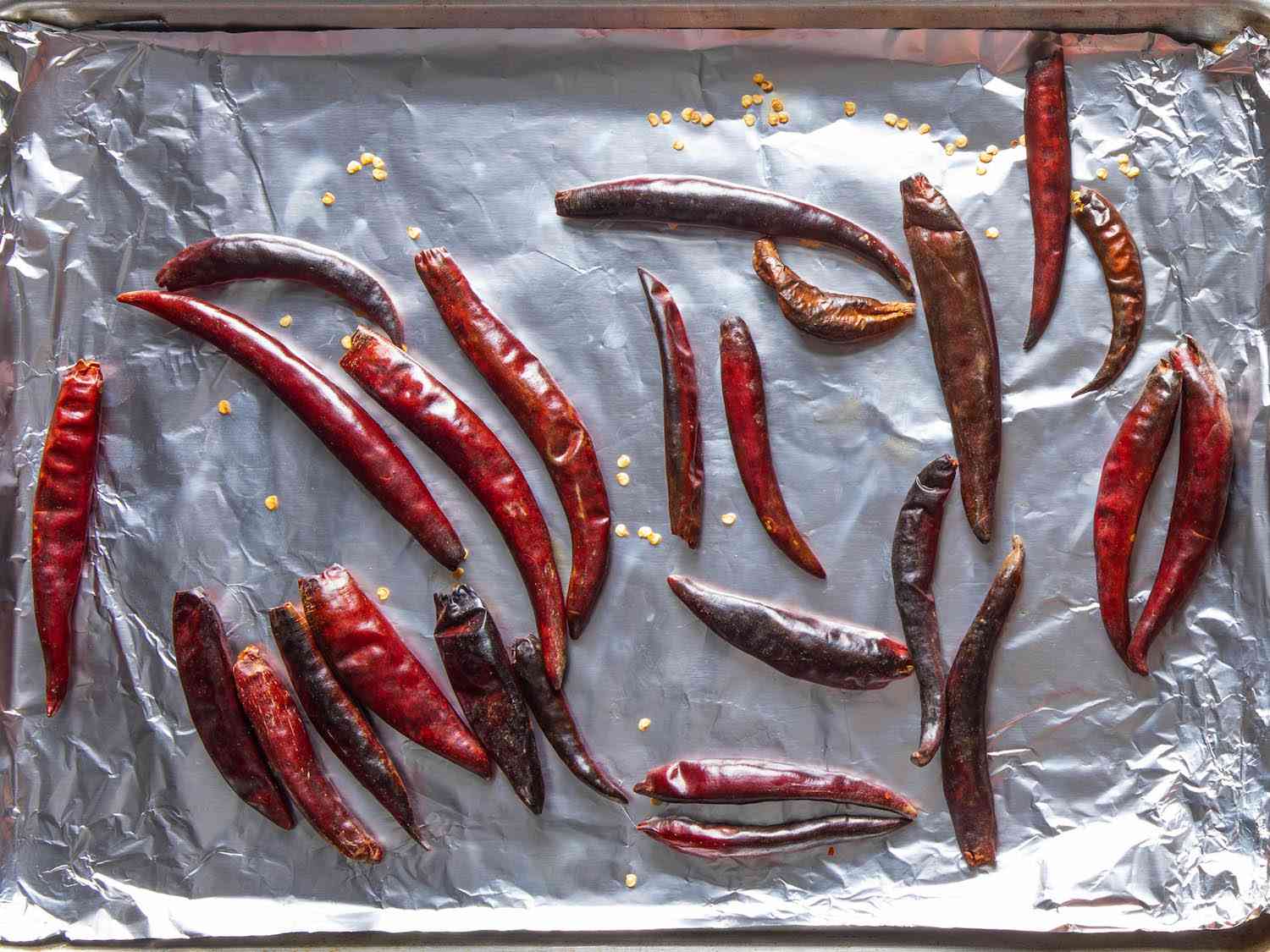将干辣椒放在锡箔衬里的烤盘上，烤至有斑点的微焦。