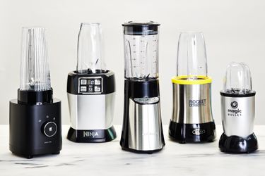 a lineup of personal blenders on a marble countertop