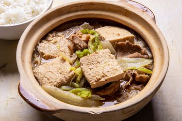服务碗冷冻猪肉炖豆腐汤,白菜,米饭面条和米饭一起